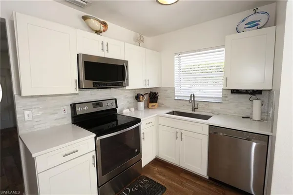 a kitchen with a sink stove and microwave