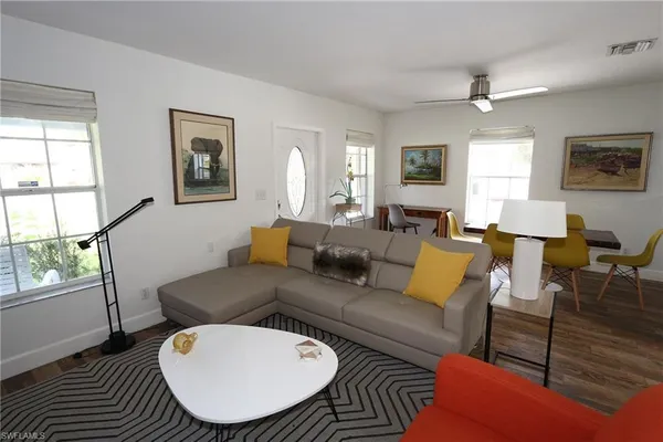 a living room with furniture a wooden floor and a window