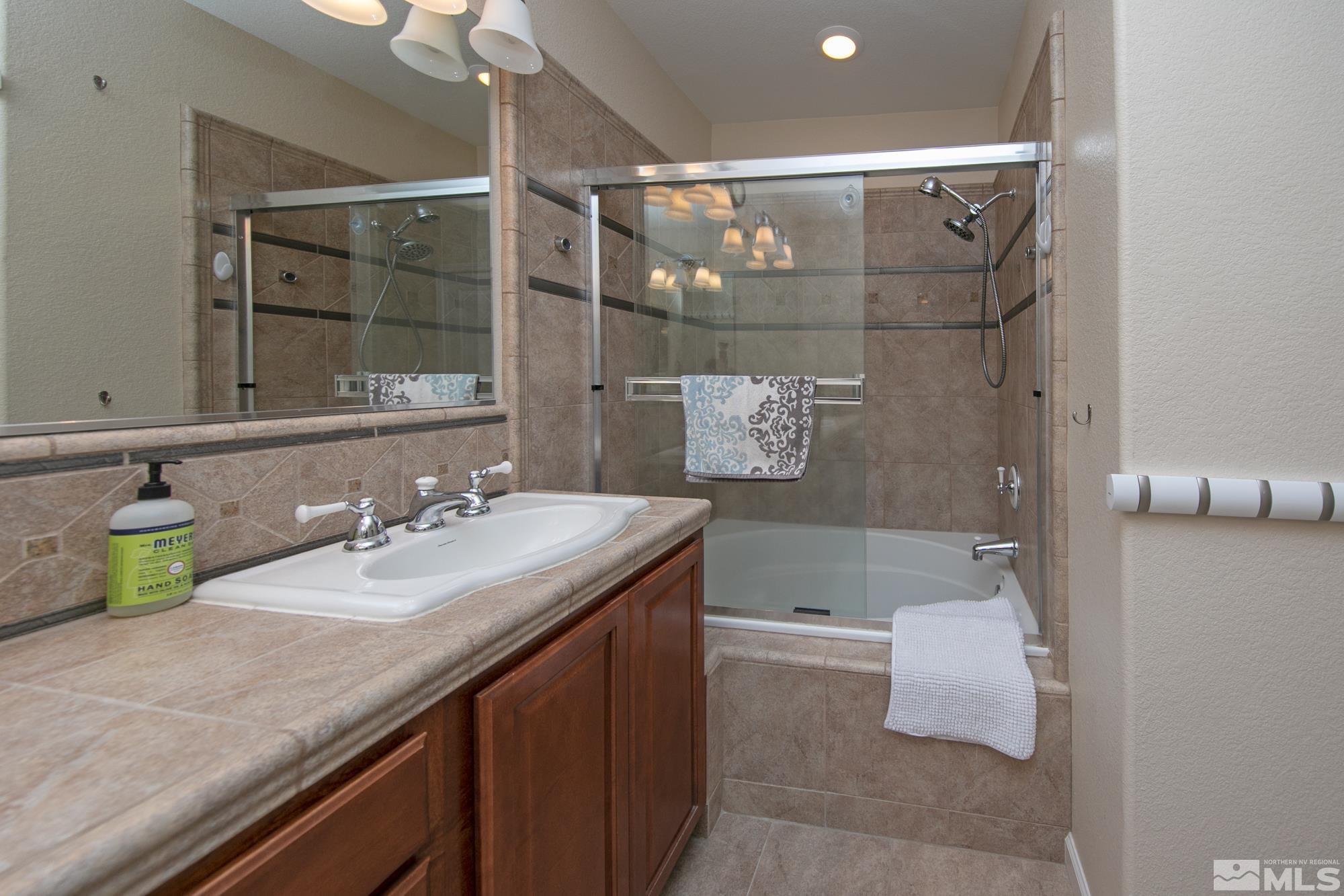 7665 Pebblestone Way Reno, NV 89523 - Photo 23 of 34 a bathroom with a granite countertop sink a toilet and shower