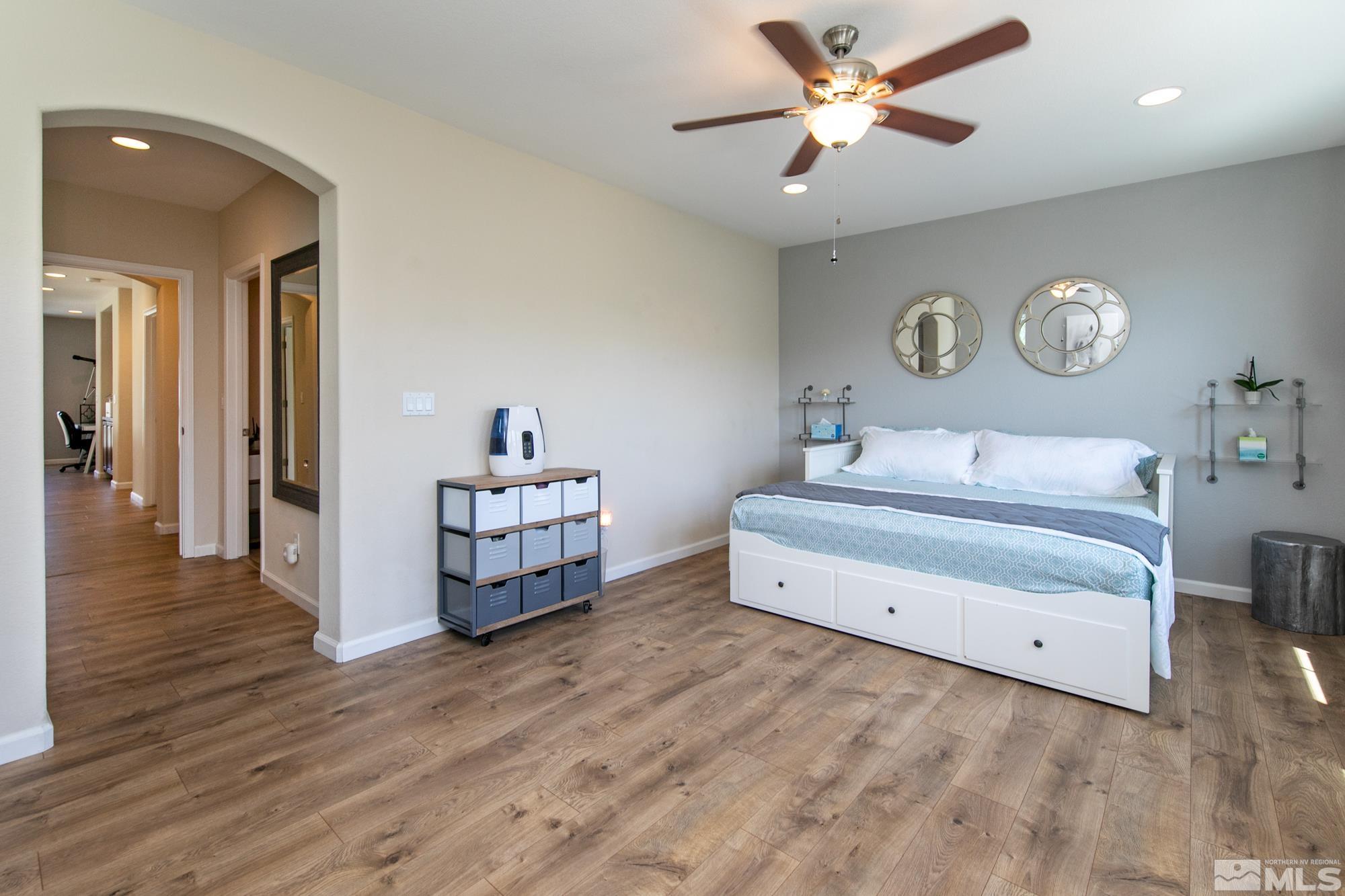 7665 Pebblestone Way Reno, NV 89523 - Photo 26 of 34 a spacious bedroom with a bed and a chandelier