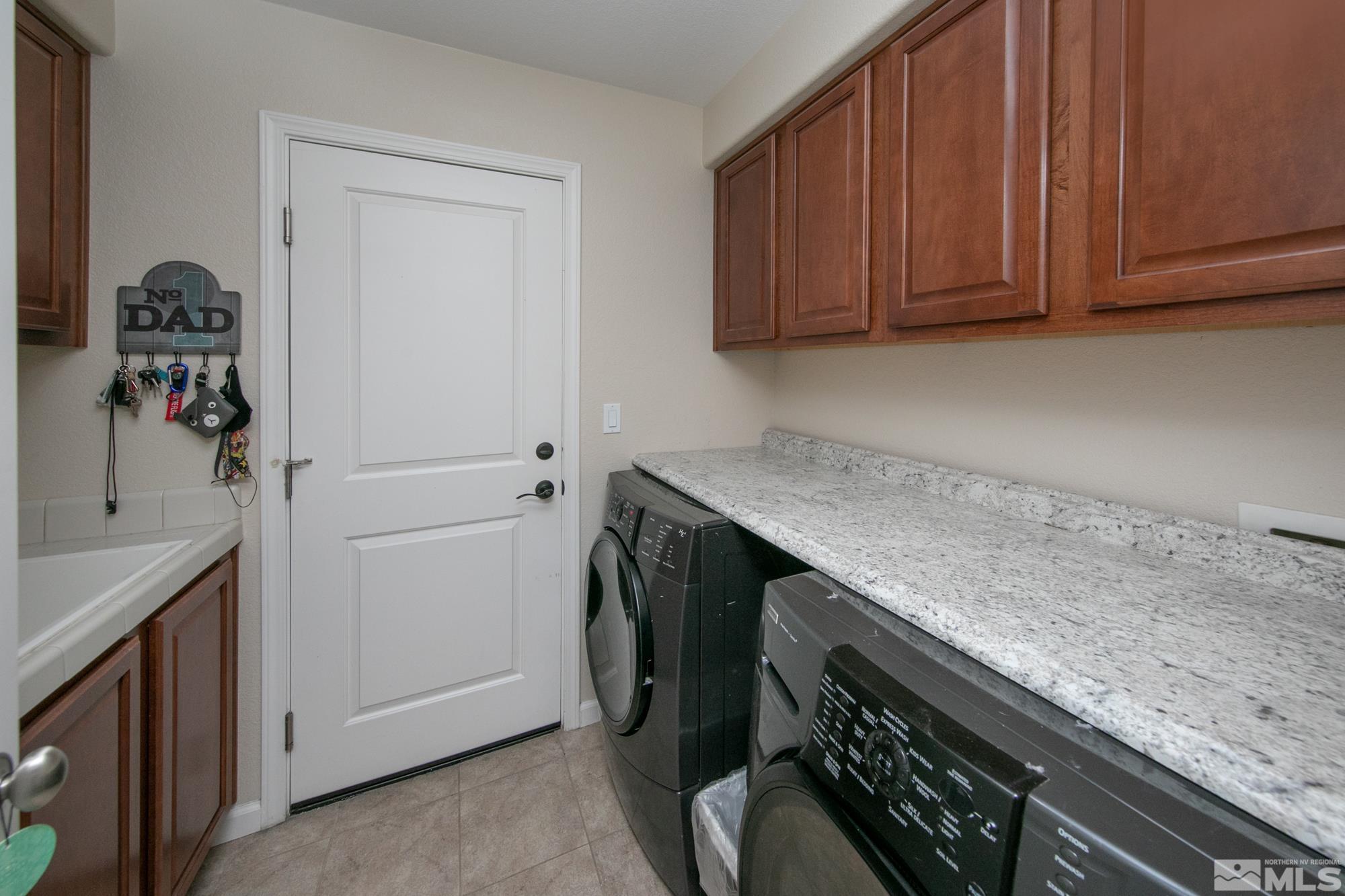 7665 Pebblestone Way Reno, NV 89523 - Photo 27 of 34 a utility room with granite countertop cabinets washer and dryer