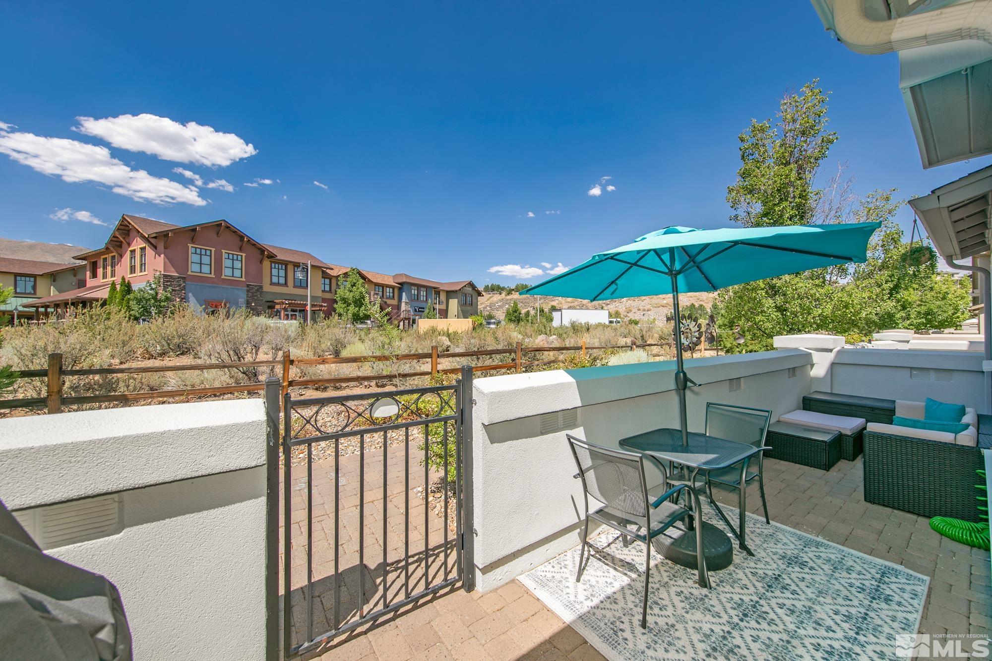 7665 Pebblestone Way Reno, NV 89523 - Photo 3 of 34 a view of a patio with table and chairs under an umbrella