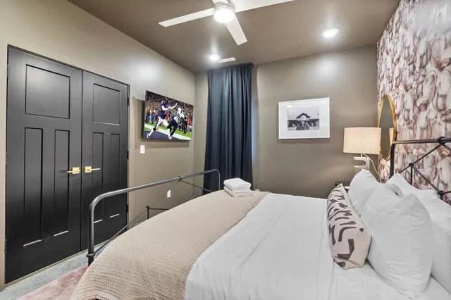 a bedroom with a bed closet and mirror