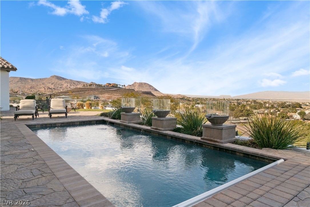 1123 Christian Road Henderson, NV 89002 - Photo 50 of 94 A refreshing pool with elegant water features offers a captivating panoramic mountain view.