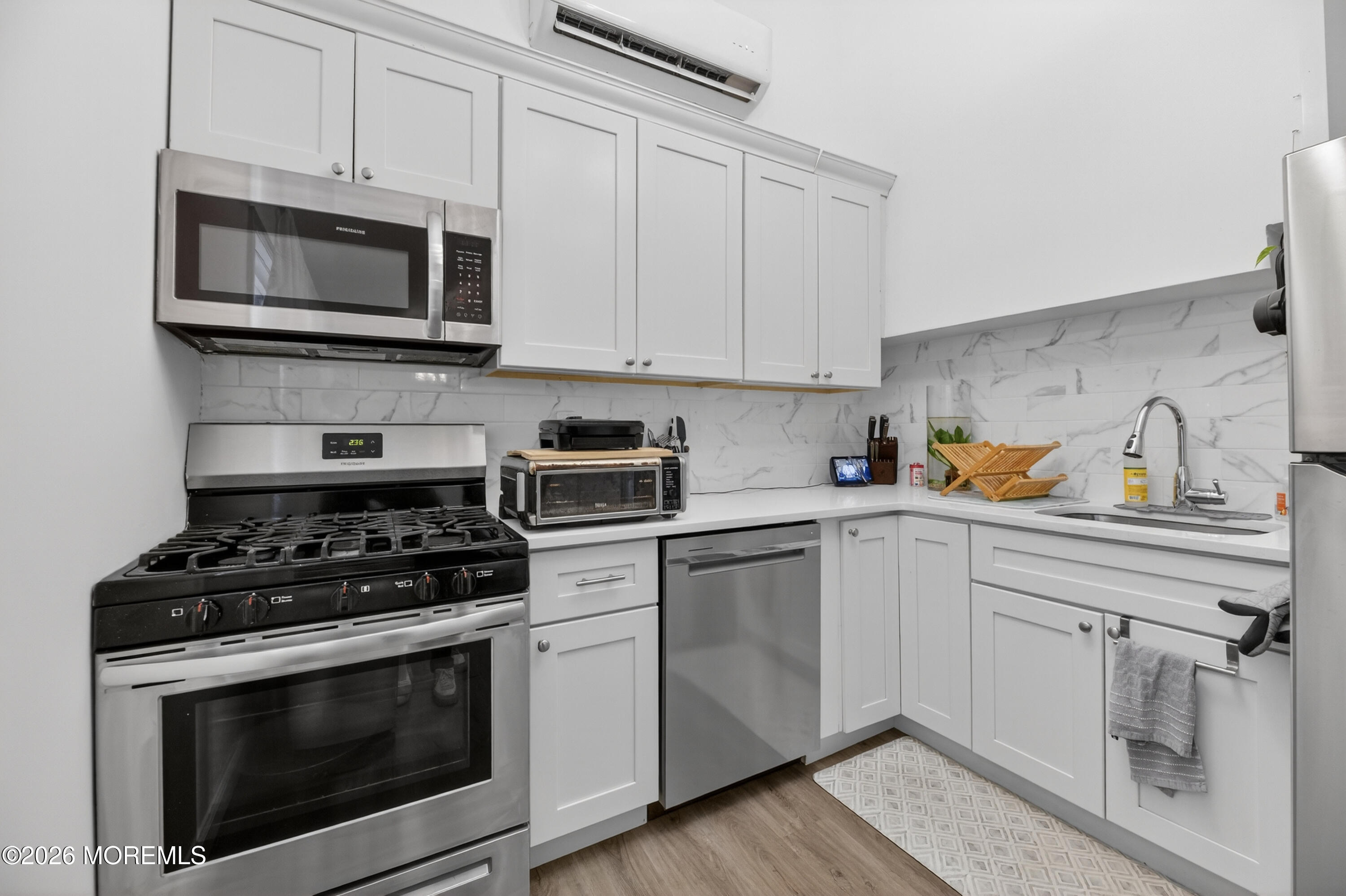21 Anderson Street Union Beach, NJ 07735 - Photo 7 of 40 a kitchen with cabinets stainless steel appliances and a wooden floor
