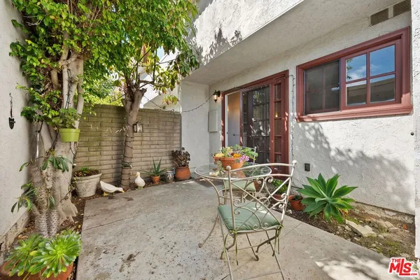 a view of a patio with table and chairs and potted plants
