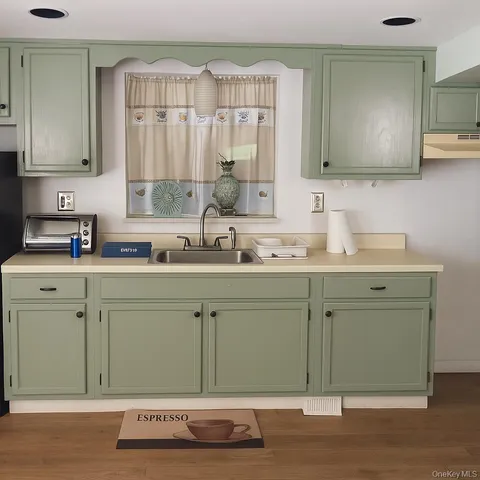 a kitchen with a sink cabinets and wooden floor