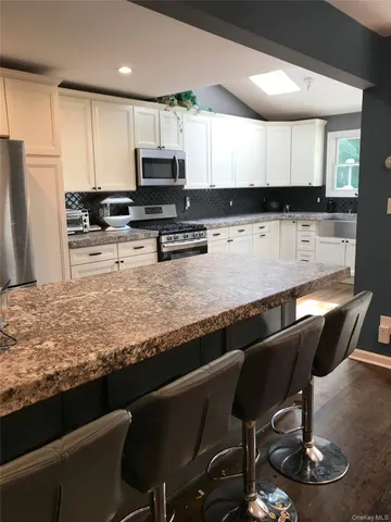 a kitchen with granite countertop lots of counter top space appliances and cabinets