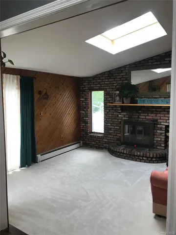 a view of an empty room with a fireplace and a window