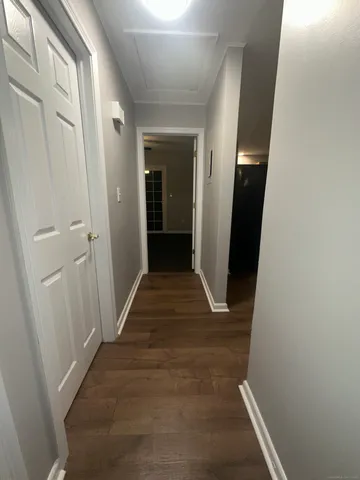 a view of a hallway with wooden floor and closet