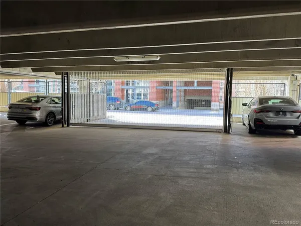 a view of a street in cars parked on the roadside