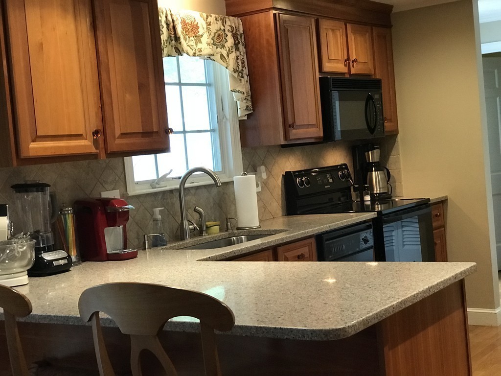 43 Mayflower Circle Hanover, MA 02339 - Photo 9 of 24 a kitchen with stainless steel appliances granite countertop a sink a stove and microwave