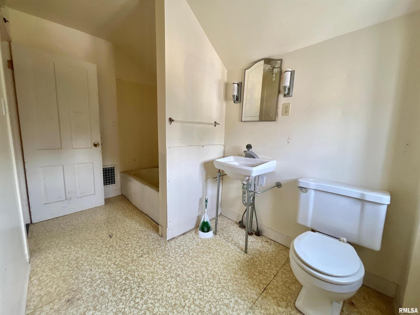 633 4th Avenue South Clinton, IA 52732 - Photo 26 of 34 a bathroom with a toilet a sink and mirror