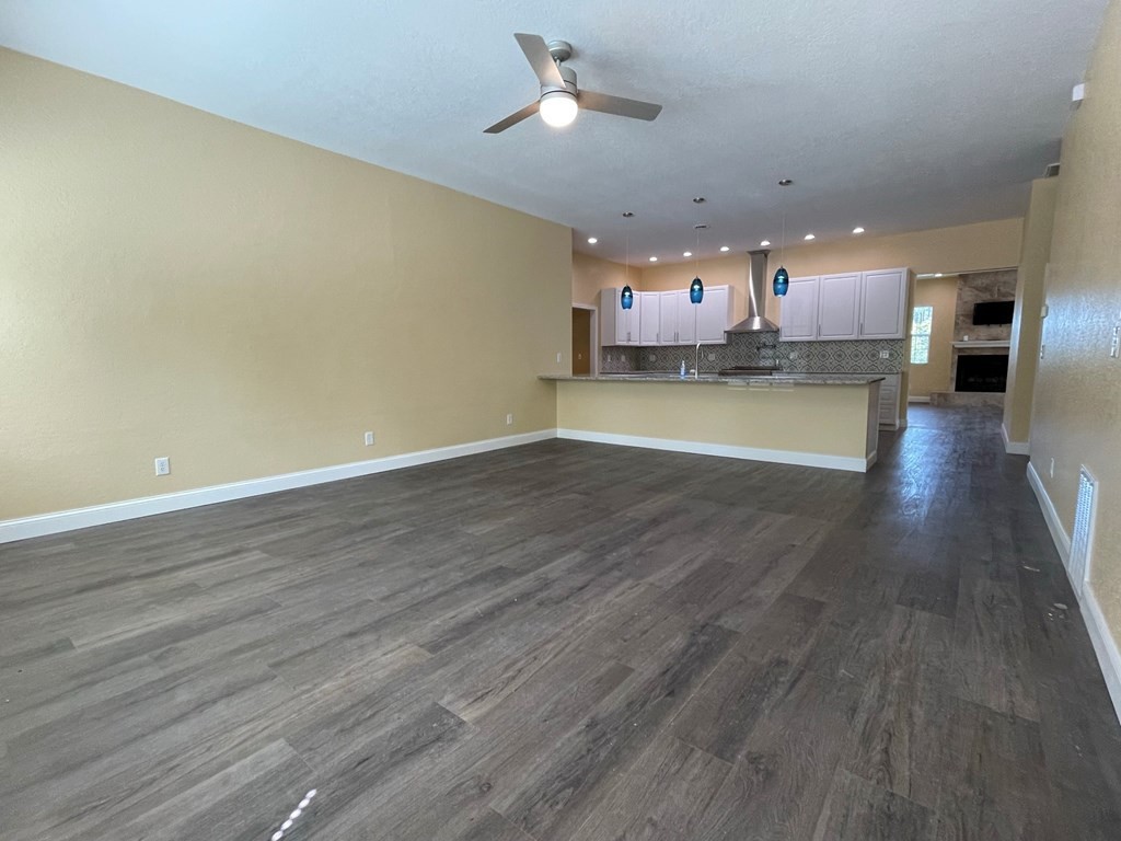 1763 Rays Gap Road Seymour, TN 37865 - Photo 10 of 34 an empty room with wooden floor and kitchen view