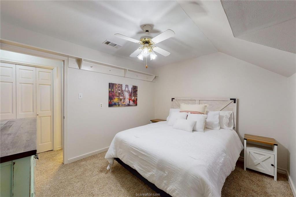 900 Westview Street Bryan, TX 77802 - Photo 28 of 30 a bedroom with a bed and a chandelier