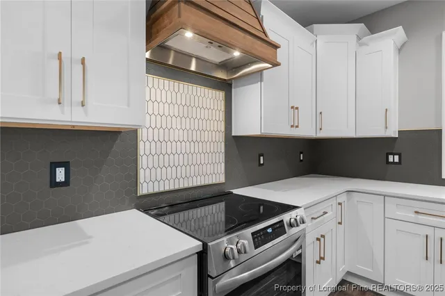a kitchen with granite countertop white cabinets and black appliances