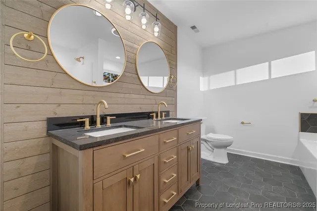a bathroom with a granite countertop toilet sink and mirror