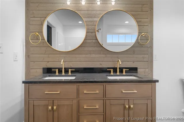 a bathroom with a granite countertop double vanity and a mirror