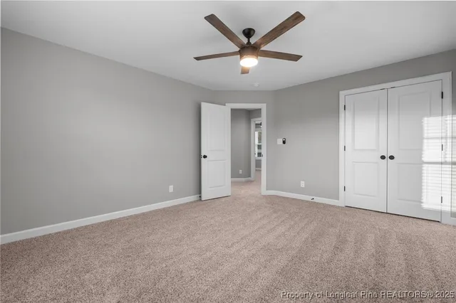 an empty room with a ceiling fan and a window