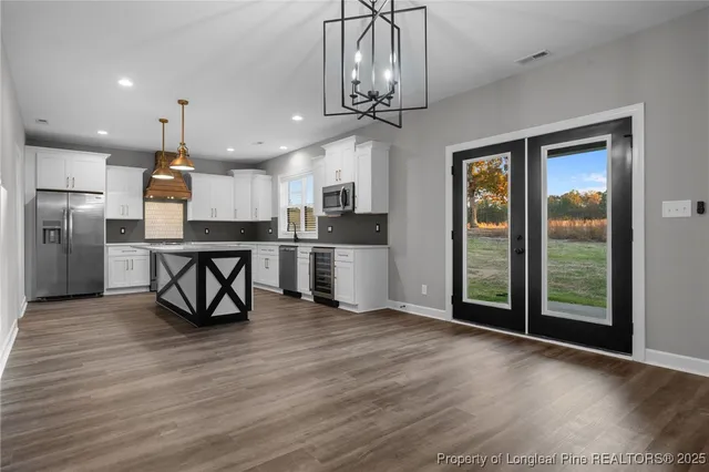 a view of a kitchen with stainless steel appliances wooden floor and a window