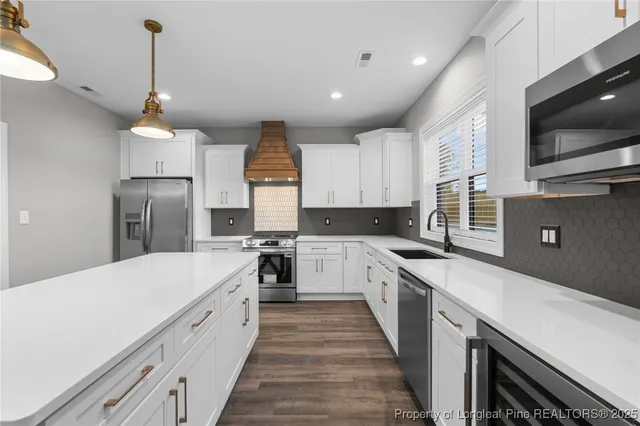 a kitchen with a sink a counter top space stainless steel appliances and cabinets