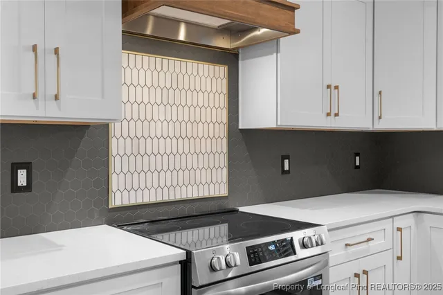 a kitchen with a stove and white cabinets