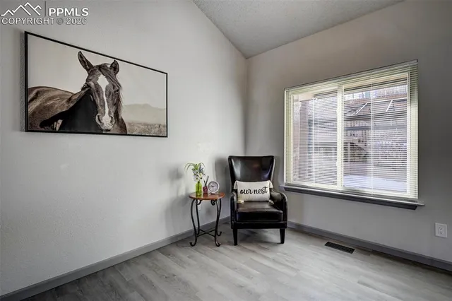a view of a workspace with furniture and a window