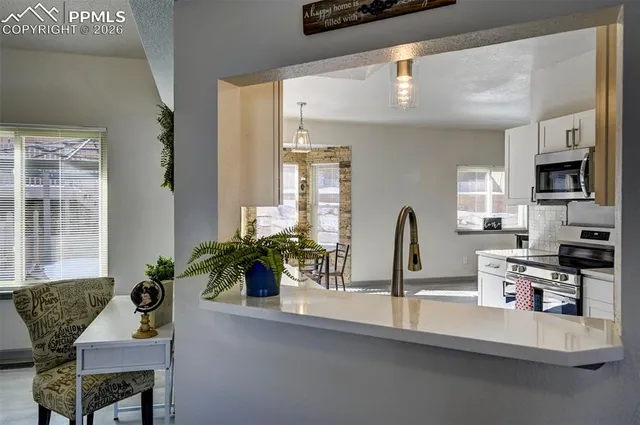a dining room with furniture and potted plants