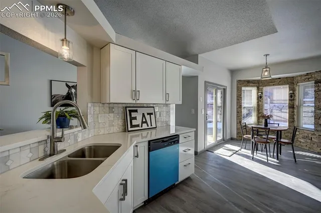 a kitchen with a sink cabinets and wooden floor