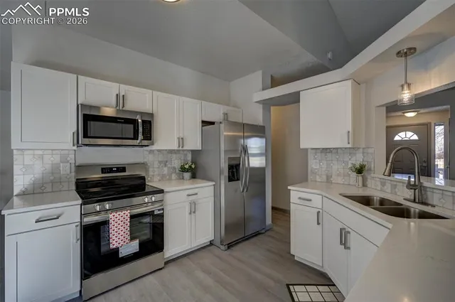 a kitchen with white cabinets and stainless steel appliances