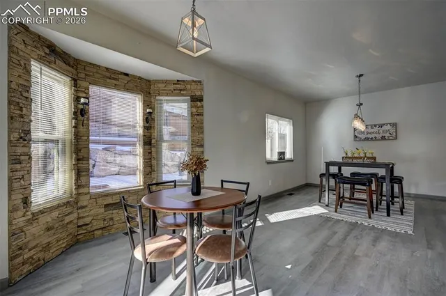 a dining room with furniture a chandelier and wooden floor