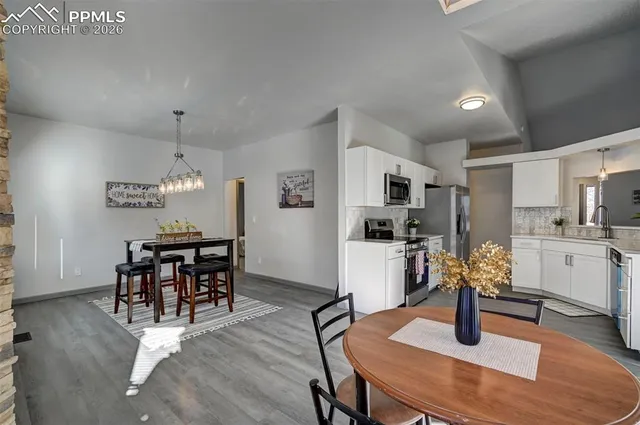 a living room with furniture and kitchen area