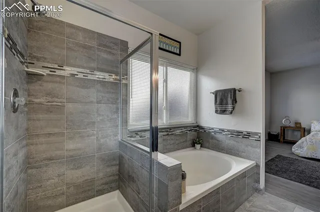 a bathroom with a tub a sink and glass door