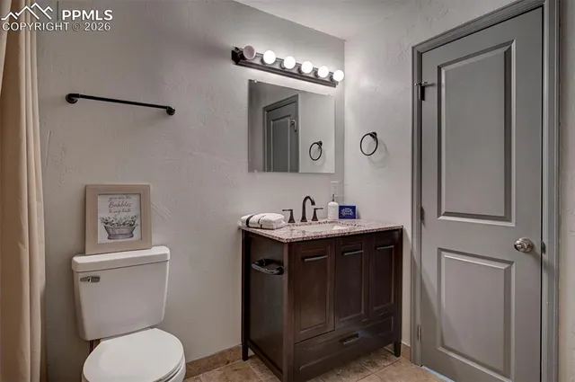 a bathroom with a toilet a sink and mirror