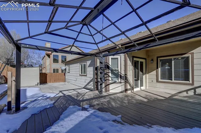 a view of a house with wooden deck and furniture