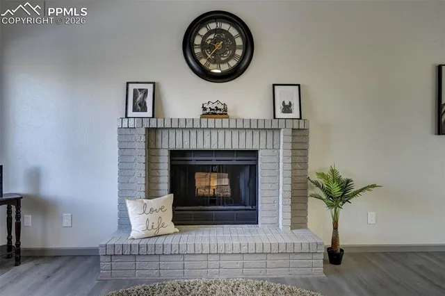 a living room with a fireplace and a potted plant