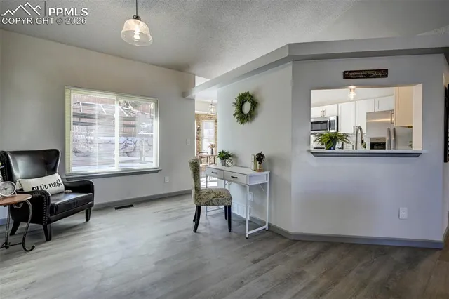 a view of a workspace with furniture and a window