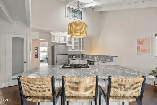a kitchen with kitchen island a stove a table and chairs in it