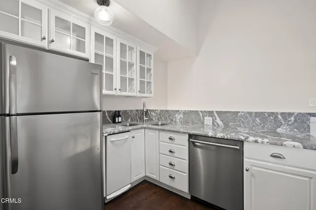 a kitchen with stainless steel appliances a stove a chimney a sink and cabinets