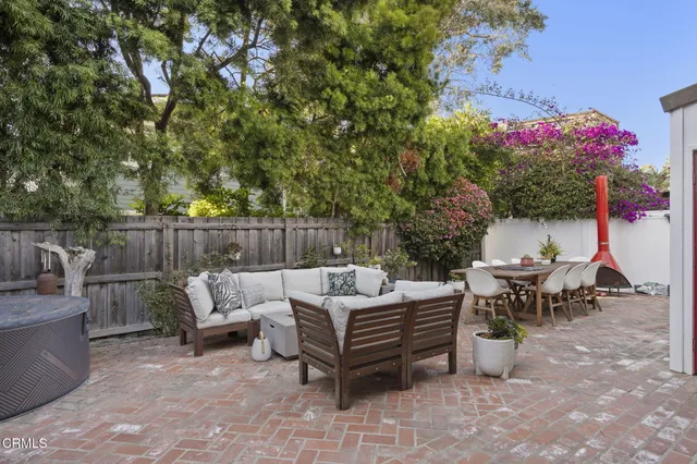 a view of a patio with couches and table and chairs with wooden floor