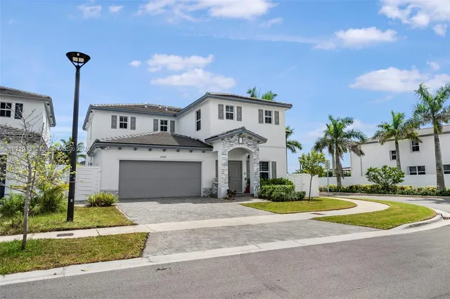 a front view of a house with a garden and plants