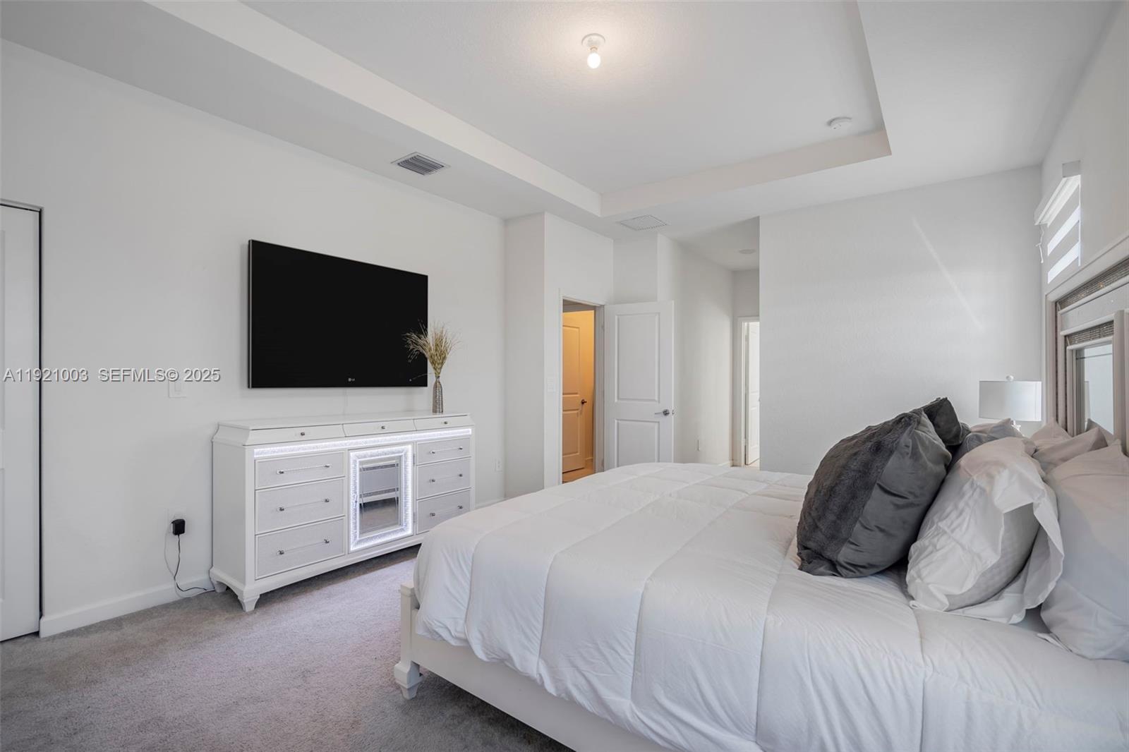 21189 Southwest 127th Court Miami, FL 33177 - Photo 23 of 46 a bedroom with a bed and a flat screen tv on the dresser