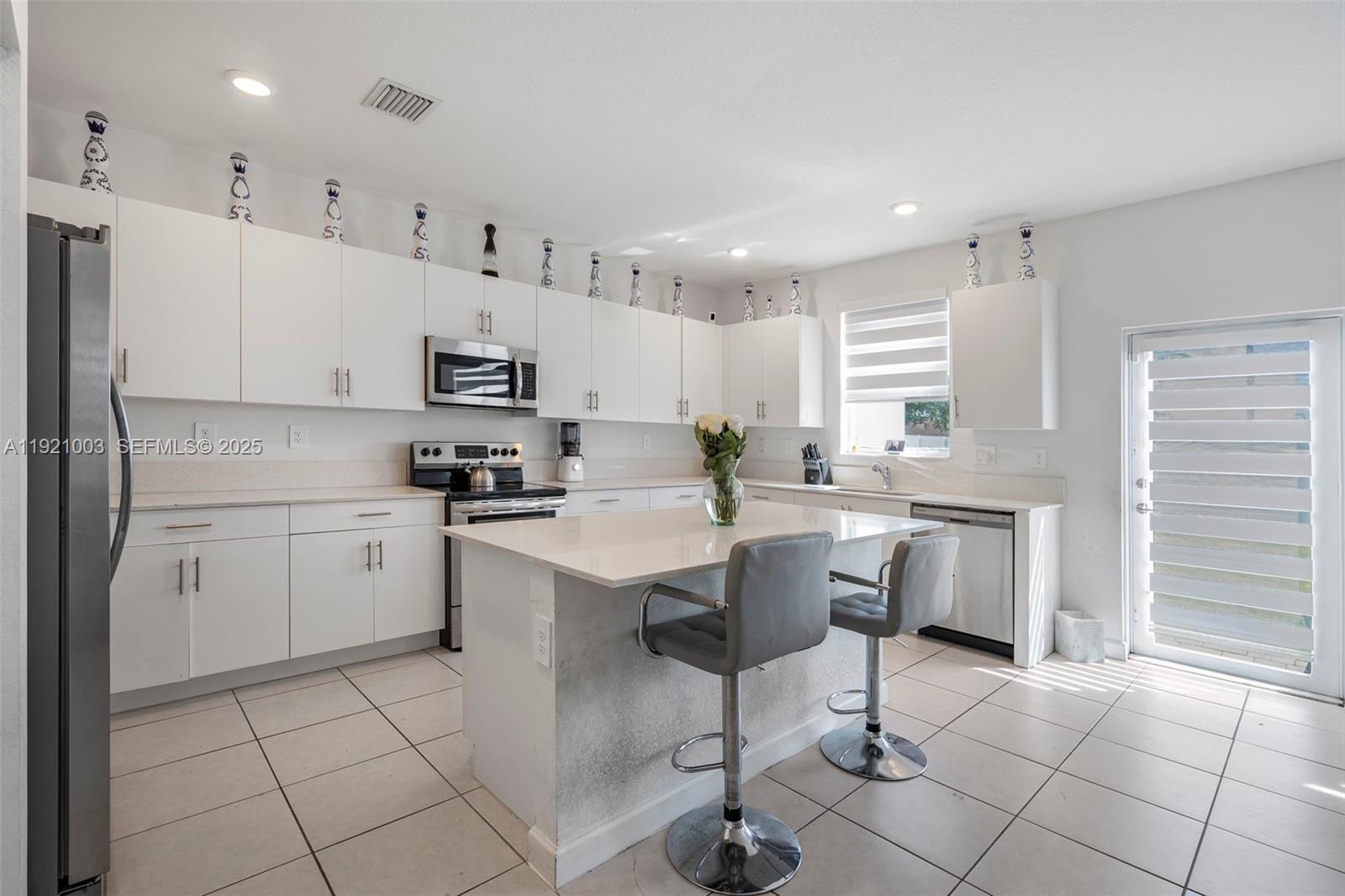 21189 Southwest 127th Court Miami, FL 33177 - Photo 7 of 46 a kitchen with a sink a counter top space appliances and cabinets
