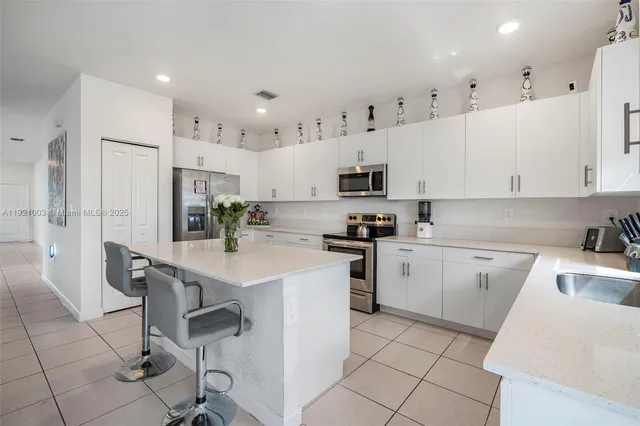 a kitchen with cabinets and chairs