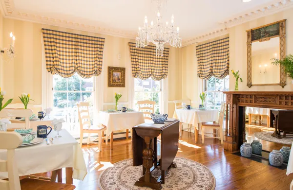 a living room with furniture large windows and wooden floor