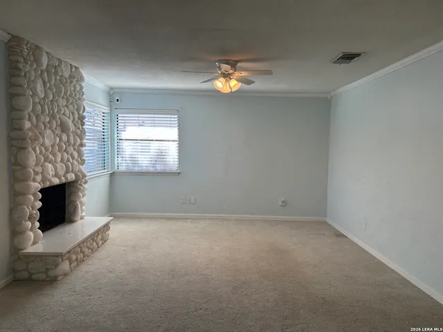 an empty room with windows and fireplace