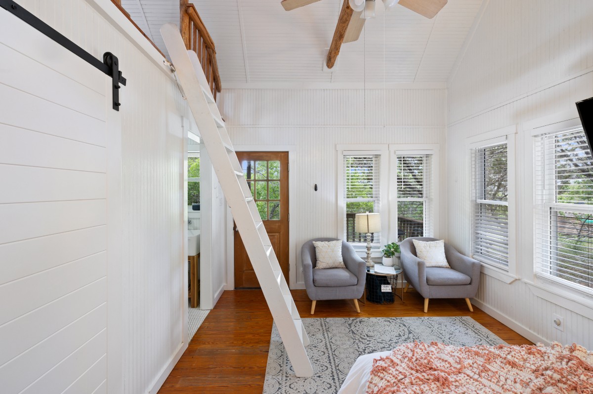 17 September Ridge Johnson City, TX 78636 - Photo 25 of 40 Sitting room featuring wood finished floors, a barn door, plenty of natural light, vaulted ceiling, and wooden walls