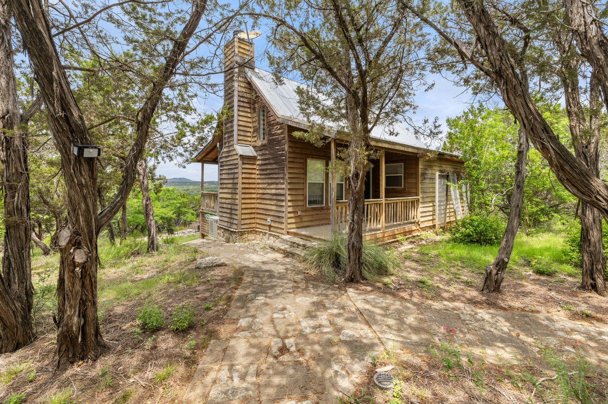 17 September Ridge Johnson City, TX 78636 - Photo 6 of 40 View of property exterior with a chimney, covered porch, and metal roof