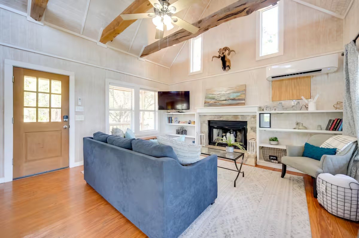 17 September Ridge Johnson City, TX 78636 - Photo 7 of 40 Living area featuring wood finished floors, a wall mounted AC, a ceiling fan, healthy amount of natural light, and high vaulted ceiling