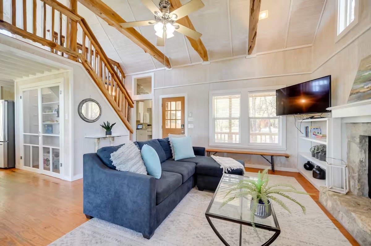 17 September Ridge Johnson City, TX 78636 - Photo 9 of 40 Living room featuring wood finished floors, a fireplace, a ceiling fan, stairway, and beam ceiling